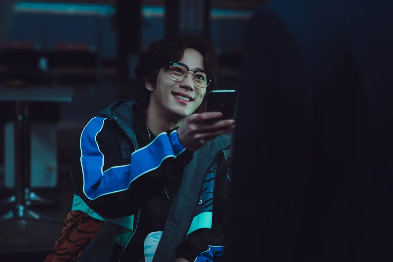 A man (Lee Jun-young as Geum Seongje) offers his smartphone to an unseen figure, in Weak Hero Class 2.